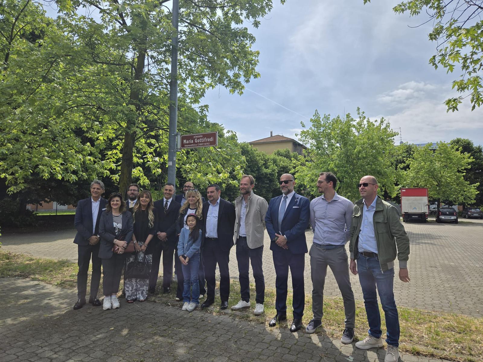 La famiglia e il team Gottifredi Maffioli posano davanti al cartello del Piazzale Maria Gottifredi durante la cerimonia di intitolazione a Novara.